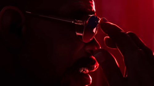 Blade fixing his glasses, with his fangs showing